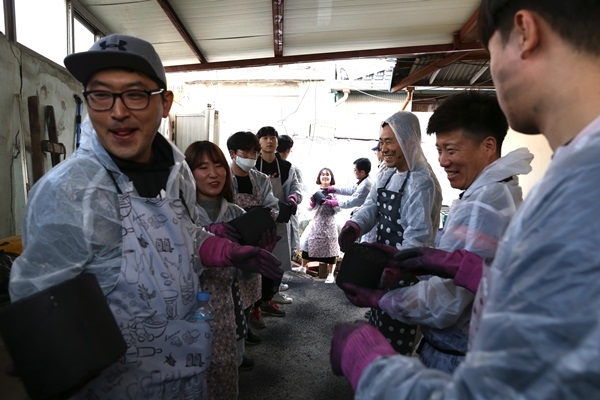 젊은잎새 봉사단원과 보해 임직원들이 23일 광주 동구 지원동에서 연탄을 나르고 있다. ⓒ보해양조 제공