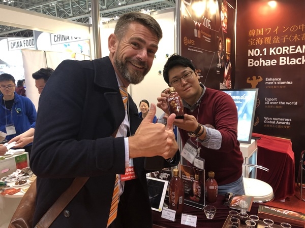 2019 일본 푸덱스 보해양조 홍보부스를 찾은 루마니아 바이어가 코리아 넘버 원 와인 복분자주를 외치고 있다. ⓒ보해양조 제공