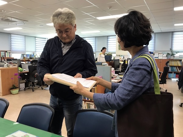 전남 구례군민들이 참여한 '좋은도서관모임' 회원들이 21일 구례군에 매천도서관과 공공도서관 통합을 촉구하는 1280명의 서명용지를 전달하고 있다. ⓒ강은경