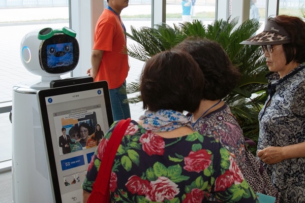 남부대 수영경기장을 찾은 관람객들이 로봇도우미 수리.달이를 살펴보고 있다. ⓒ광주시청 제공