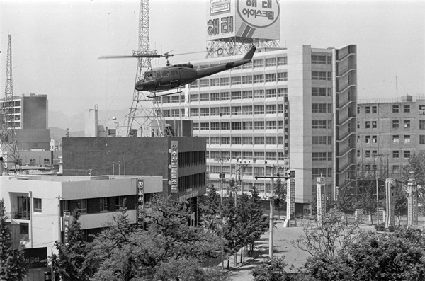 1980년 5월 당시 금남로 상공에 있는 계엄군 헬기. 해태 아이스크림 광고탑 건물은 헬기기총소사 총탄 흔적이 발견된 전일빌딩. 나경택 전 '전남매일' 기자. ⓒ5·18기념재단 제공