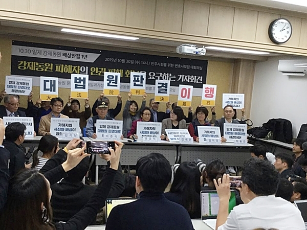 30일 오후 민주사회를 위한 변호사모임대회의실에서 '강제동원 피해자의 인권회복을 요구하는 기자회견' 에서 참석자들이 "대법원 판결을 이행하라"라는 손팻말을 들고 있다. ⓒ근로정신대할머니와 함께하는 시민모임 제공