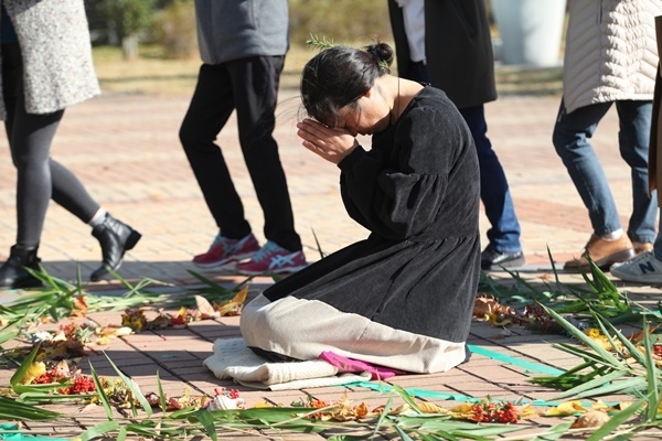 김키미 활동가가 14일 영산강 환경청 앞 텐트노숙농성을 정리하면서 비자림지키기 시민모임과 함께 써클댄스 행위극을 펼치며 기도하고 있다. ⓒ광주인