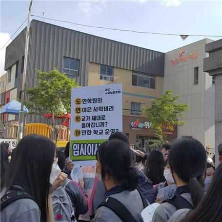 광주교사노조가 최근 명진고 앞에서 손아무개 교사 부당해임과 학내비리 의혹에 대해 집회를 개최한 가운데 재학생들이 지켜보고 있다. ⓒ광주교사노조 제공